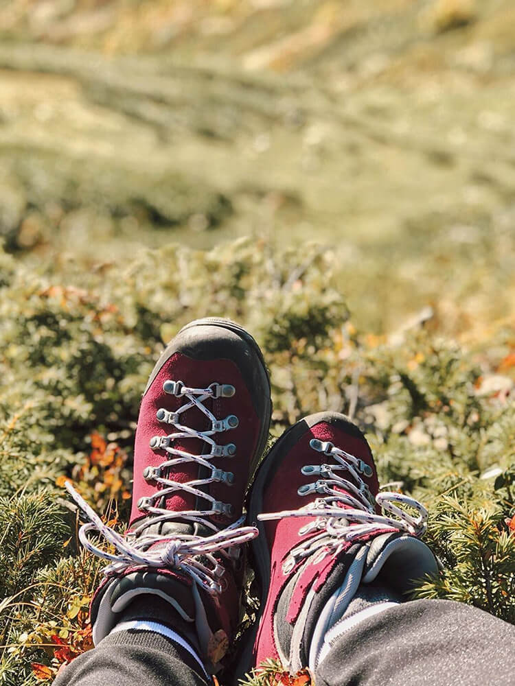 Detail nohou v botách Asolo a relax na horské louce